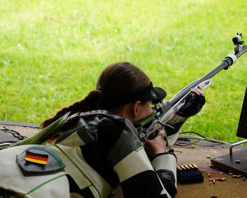 Eine Sportschützin im Liegendanschlag mit einem KK-Gewehr von schräg hinten gesehen. (Foto:DSB)